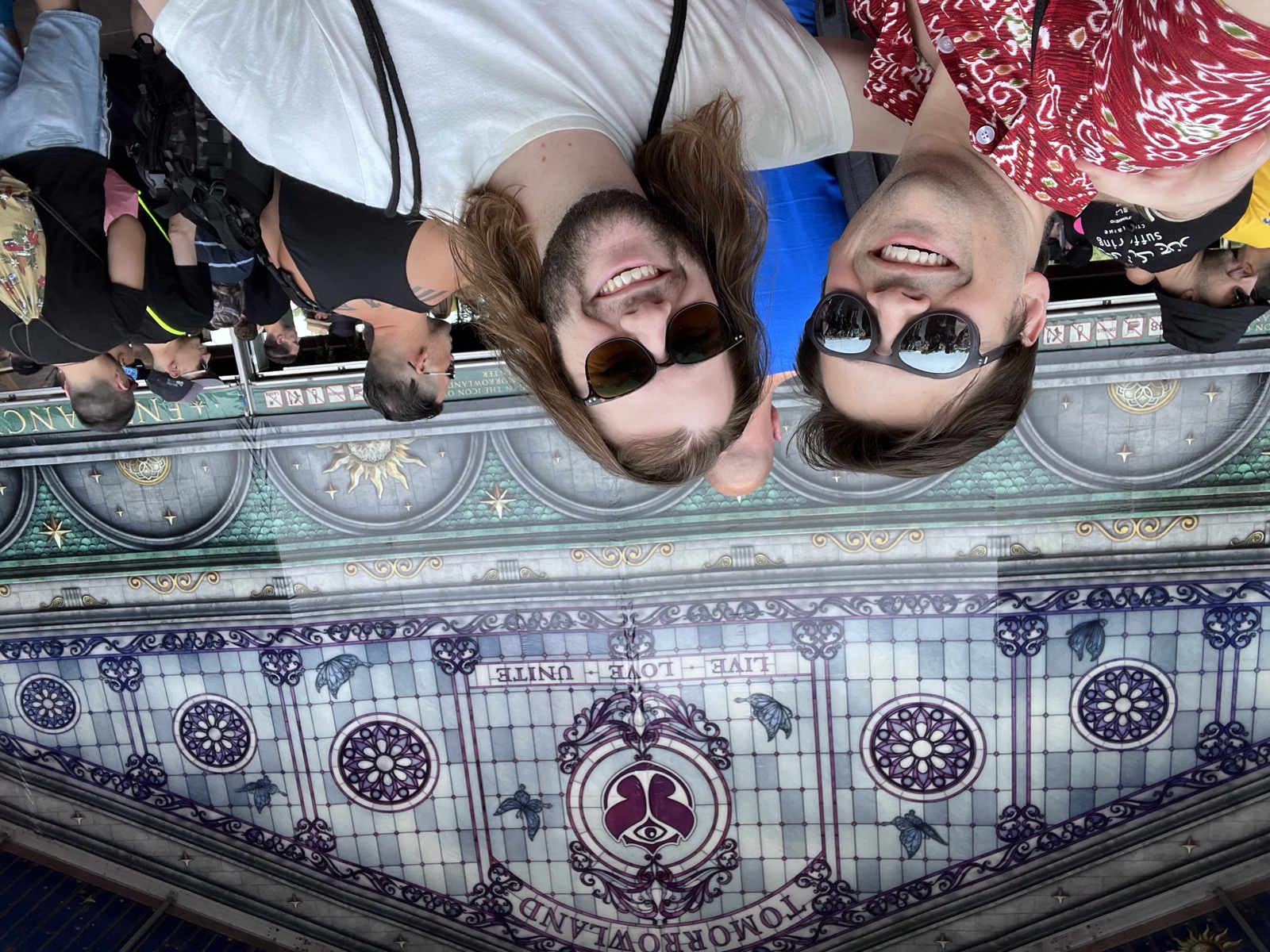 Riley and James in front of the Tomorrowland stained-glass Gathering wall, 2022